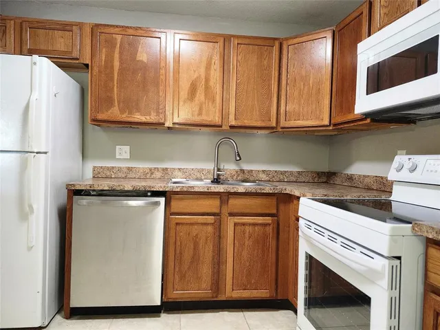 a kitchen with granite countertop cabinets stainless steel appliances and a sink