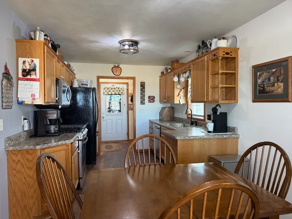 a kitchen with granite countertop a refrigerator stove and microwave