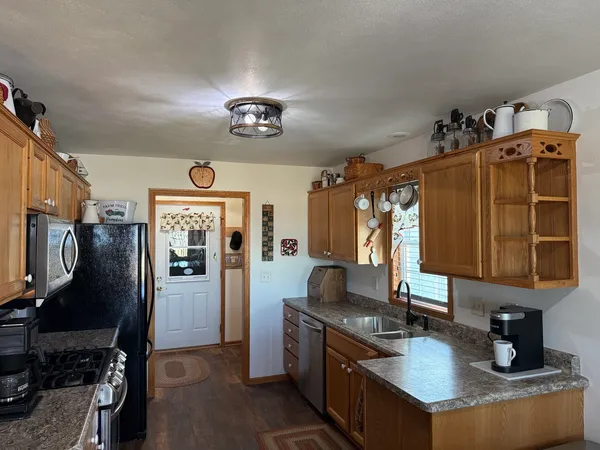 a kitchen with stainless steel appliances a stove a microwave a dining table and chairs