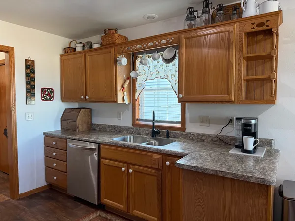 a kitchen with granite countertop a stove a sink and a dining table with chairs