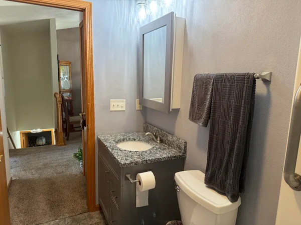 a kitchen with stainless steel appliances granite countertop a refrigerator a stove a sink a dining table and chairs