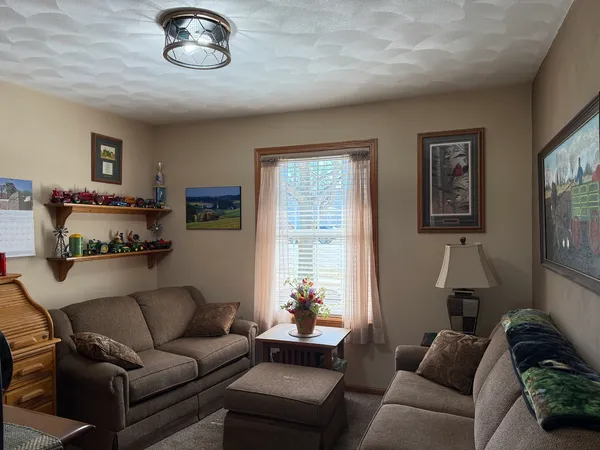 a open kitchen with stainless steel appliances granite countertop a refrigerator a sink dishwasher a dining table and chairs with wooden floor