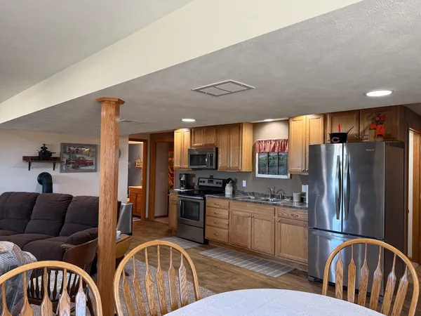a living room with furniture a flat screen tv and kitchen view