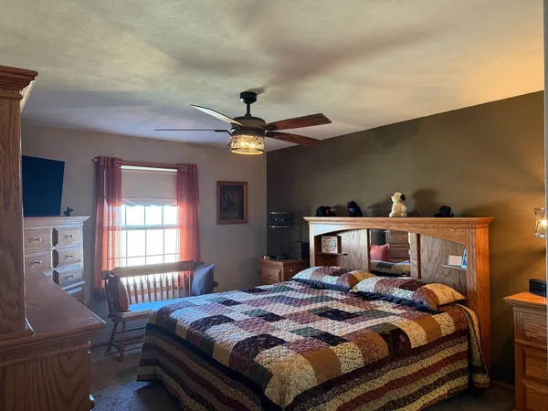 a bedroom with a bed and a large mirror on the dresser