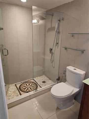 an empty room with wooden floor closet and windows