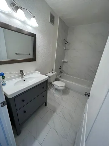 a bathroom with a double vanity sink mirror and toilet