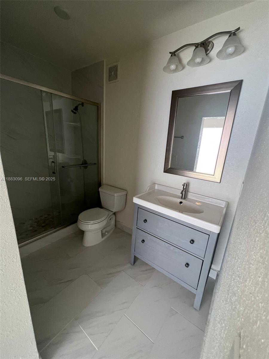 17018 Southwest 138th Court Miami, FL 33177 - Photo 12 of 22 a bathroom with a toilet sink and mirror