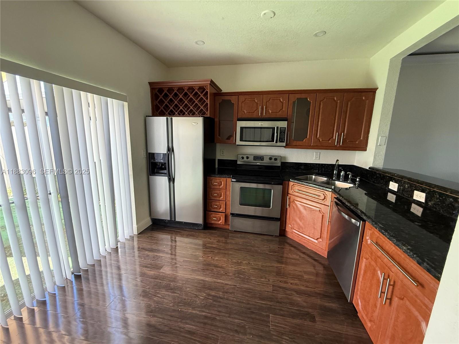 17018 Southwest 138th Court Miami, FL 33177 - Photo 21 of 22 a kitchen with stainless steel appliances granite countertop a stove a sink and a refrigerator