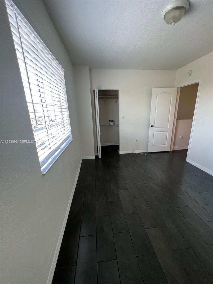 17018 Southwest 138th Court Miami, FL 33177 - Photo 8 of 22 a view of an empty room with wooden floor and a window