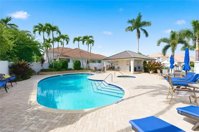 a swimming pool with outdoor seating yard and palm tree