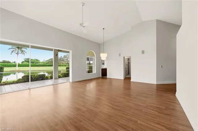 a view of empty room with wooden floor and window