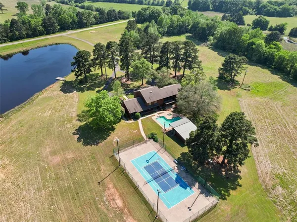 an aerial view of a house with a garden and lake view