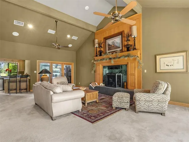 a living room with furniture a fireplace and a chandelier