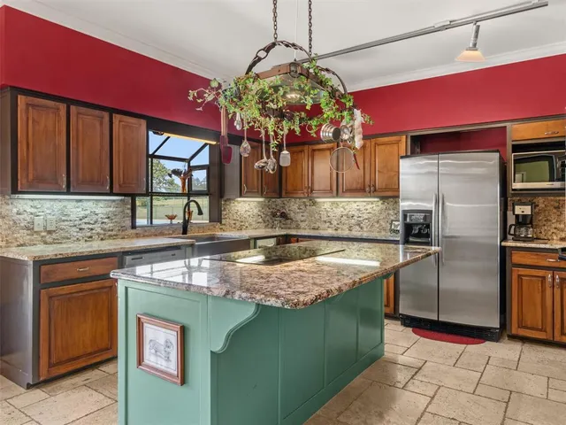 a kitchen with stainless steel appliances granite countertop a sink stove and refrigerator