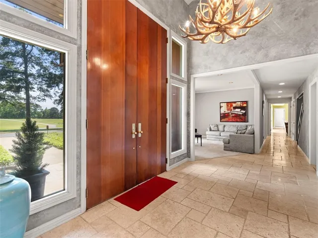 a view of a hallway with couches and red chairs