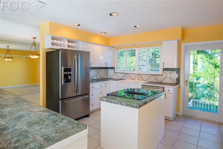 1342 Sand Castle Road Sanibel, FL 33957 - Photo 6 of 17 a kitchen with stainless steel appliances granite countertop a refrigerator and a sink