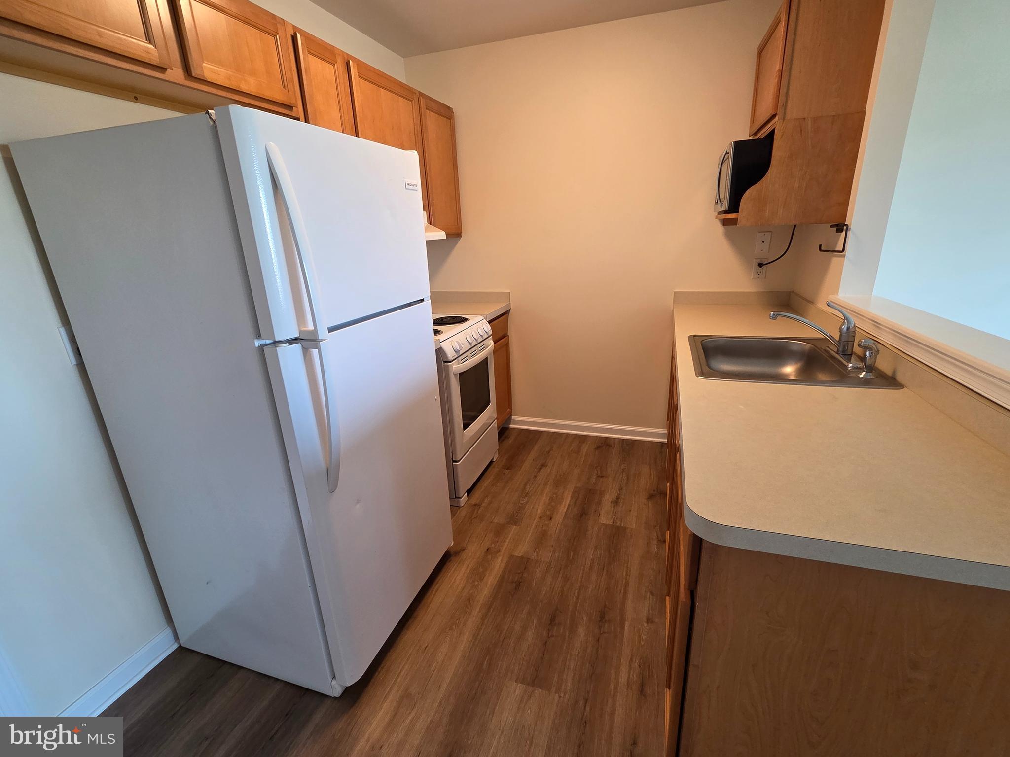 101 Dundee Avenue, Unit 202 Chester, MD 21619 - Photo 3 of 12 a kitchen with wooden floor and electronic appliances