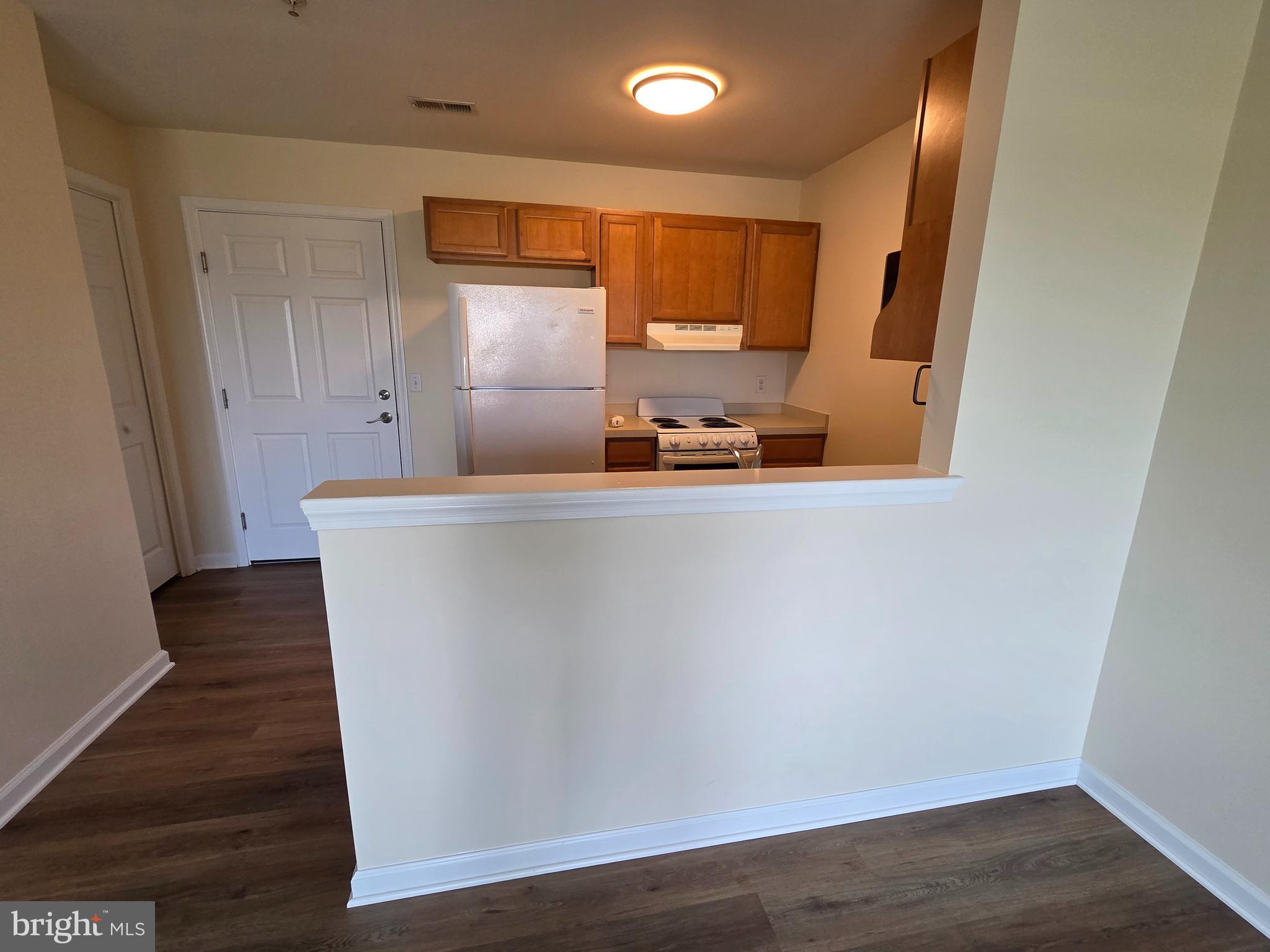 101 Dundee Avenue, Unit 202 Chester, MD 21619 - Photo 5 of 12 a view of a kitchen with wooden floor and electronic appliances