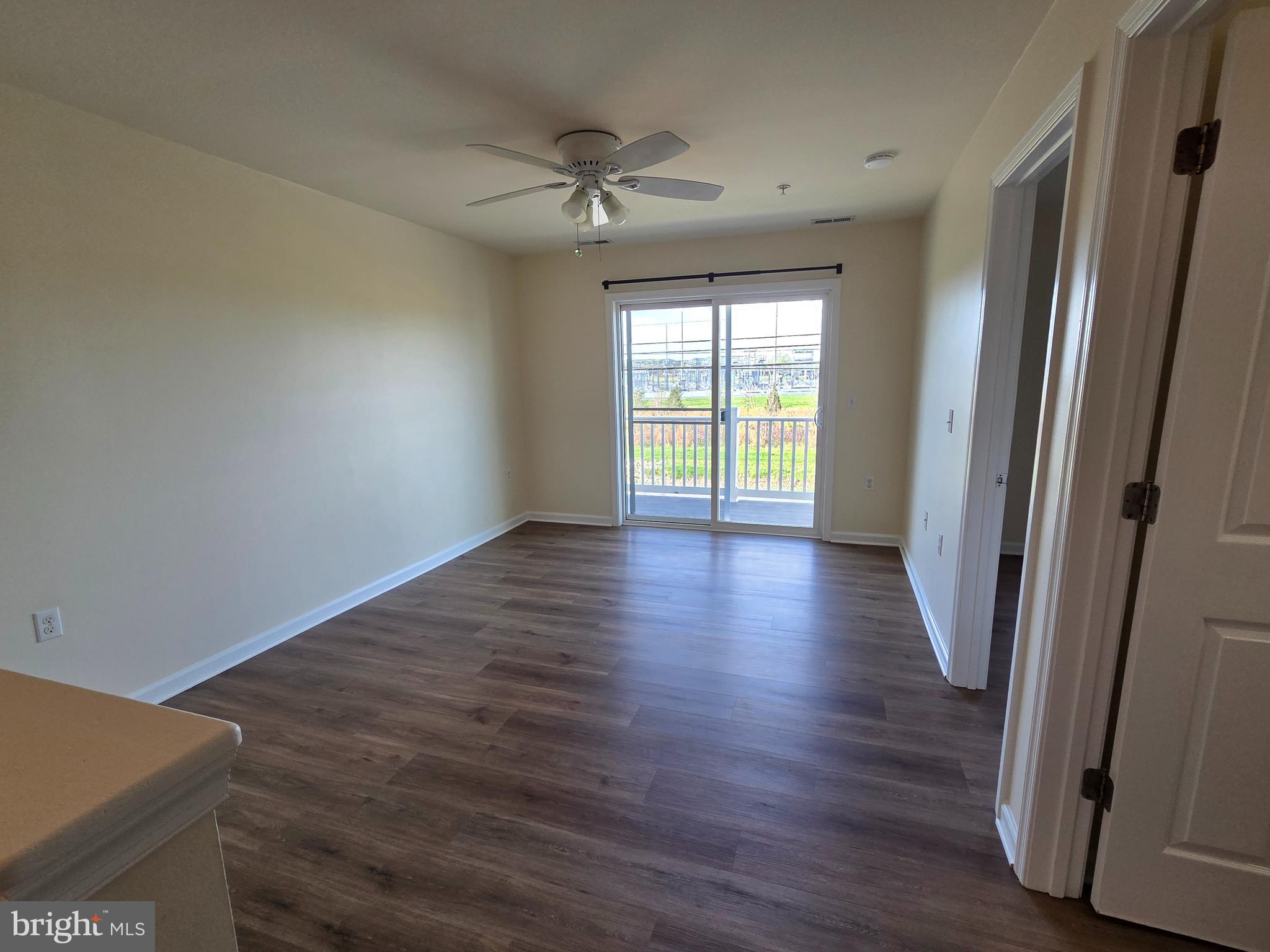 101 Dundee Avenue, Unit 202 Chester, MD 21619 - Photo 6 of 12 an empty room with wooden floor and windows