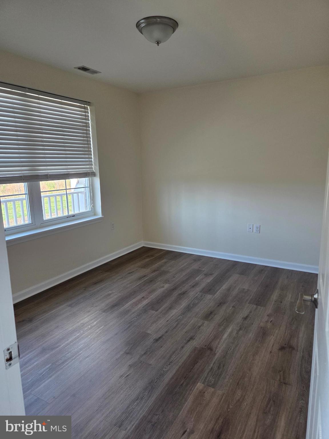 101 Dundee Avenue, Unit 202 Chester, MD 21619 - Photo 7 of 12 an empty room with wooden floor and windows