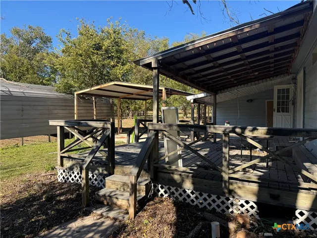 a view of a patio with table and chairs barbeque potted plants and large tree