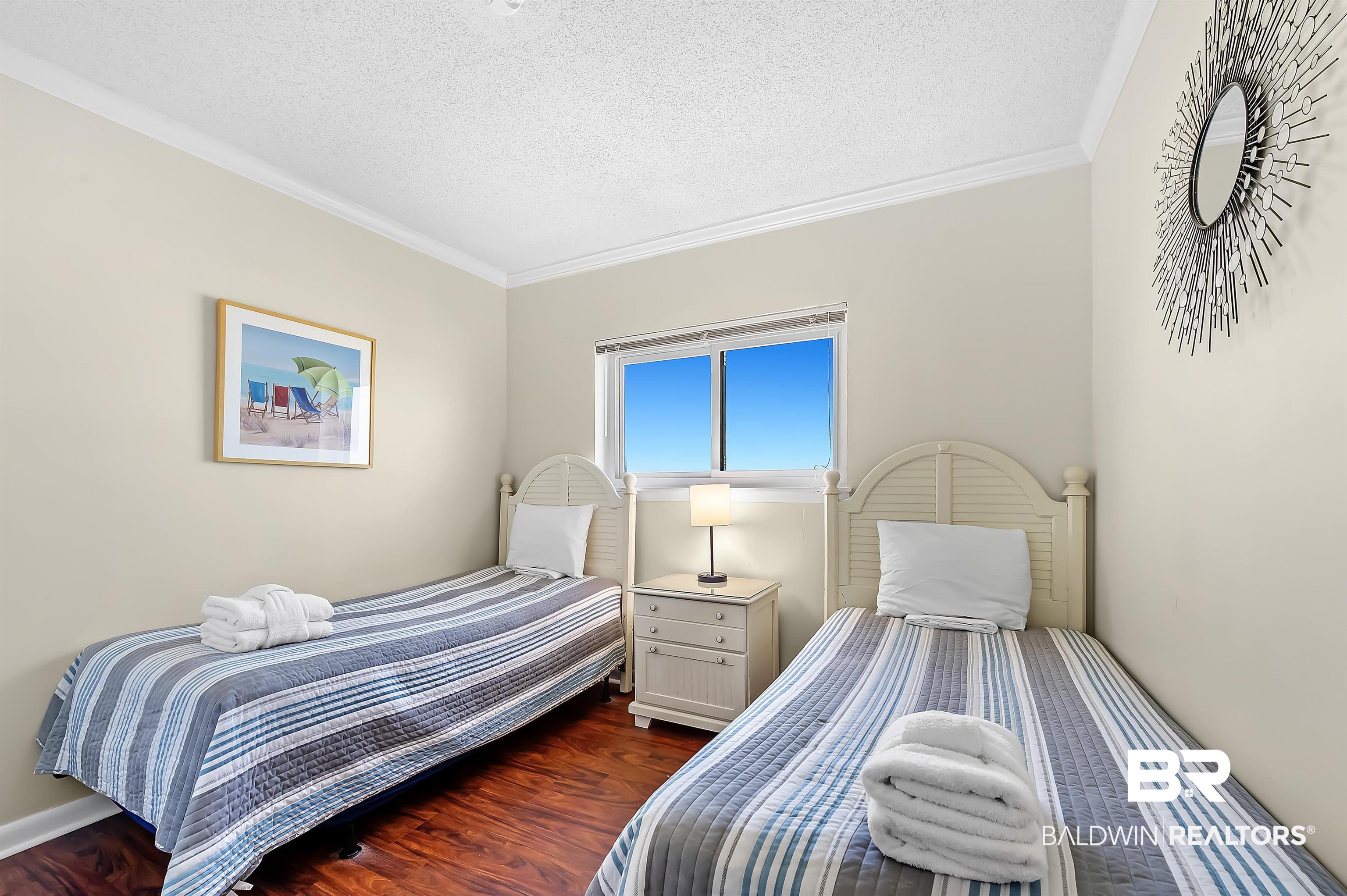 375 Plantation Road, Unit 5409 Gulf Shores, AL 36542 - Photo 22 of 48 Bedroom with a textured ceiling, dark hardwood / wood-style flooring, and ornamental molding