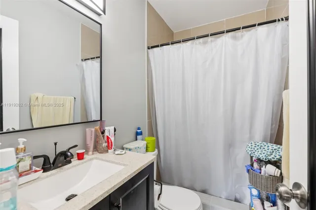 a bathroom with a sink a toilet and shower curtain