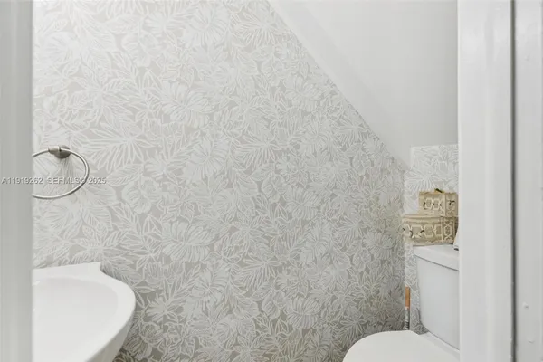 a bathroom with a granite countertop toilet and a sink