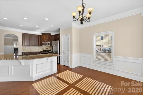 a kitchen with kitchen island white cabinets and stainless steel appliances