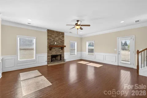 a view of a livingroom with wooden floor and a fireplace