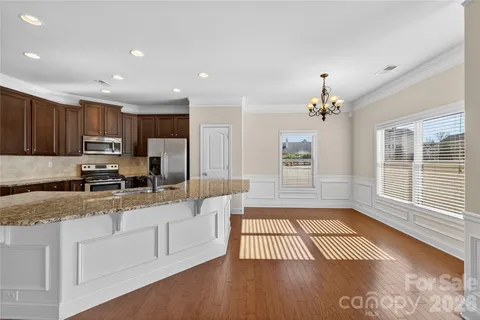 a kitchen with granite countertop a stove a sink and a refrigerator