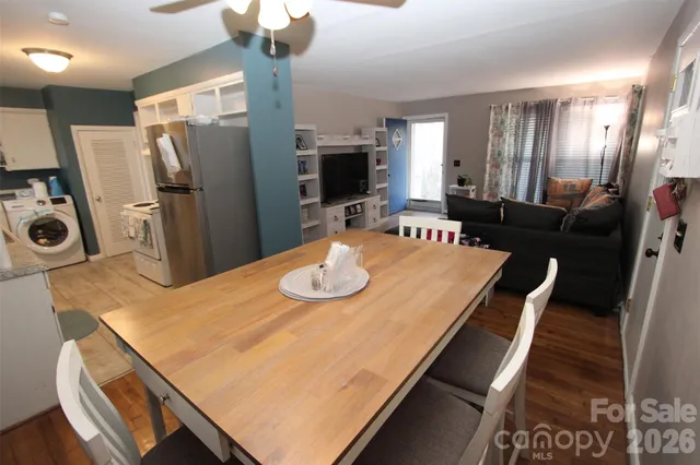 a dining room with stainless steel appliances furniture a chandelier a kitchen view and a chandelier