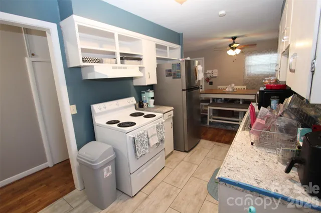 a kitchen with white cabinets and sink
