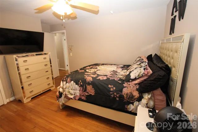 a bedroom with a bed and a flat tv screen on dresser