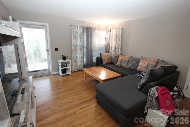 a living room with furniture a flat screen tv and a floor to ceiling window