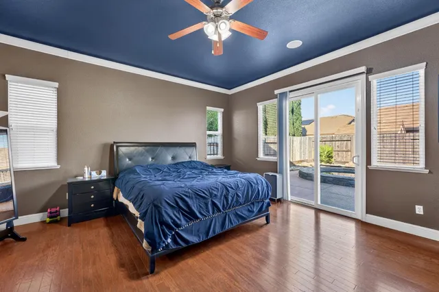 a spacious bedroom with a bed and wooden floor