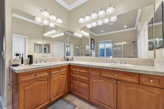 a bathroom with a granite countertop shower a sink and a mirror