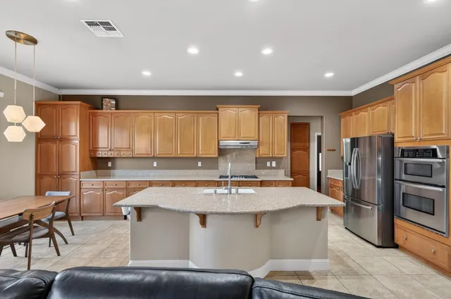 a kitchen with stainless steel appliances granite countertop a sink refrigerator and cabinets