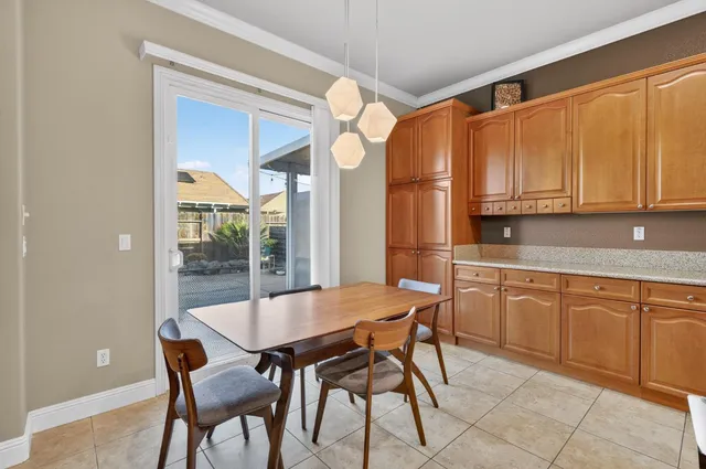 a kitchen with granite countertop a table chairs stove and cabinets