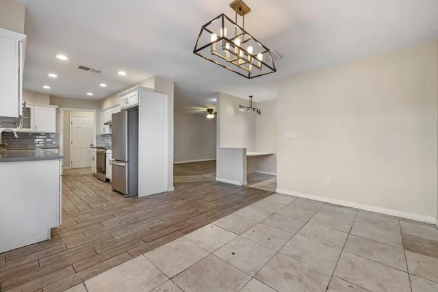 a view of an empty room with window and wooden floor