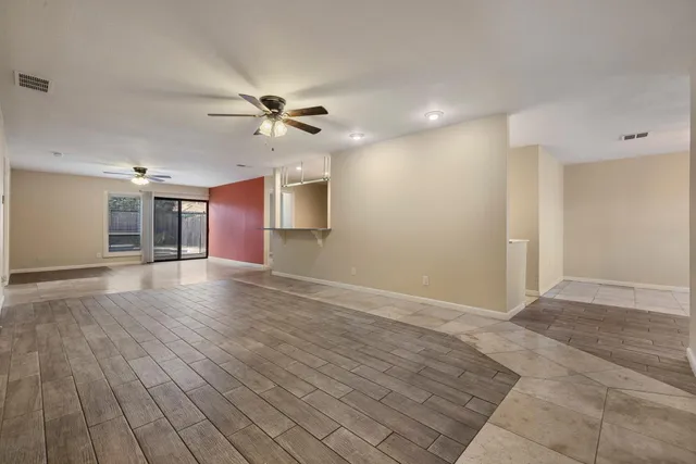 a view of a livingroom with a chandelier fan and windows