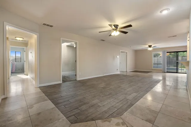 an empty room with a chandelier fan