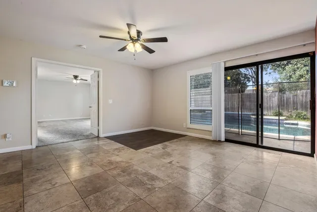 a view of a hallway with a chandelier fan and windows