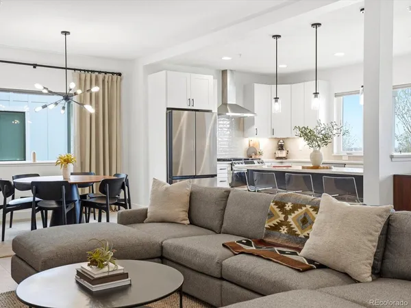 a living room with furniture kitchen and a chandelier