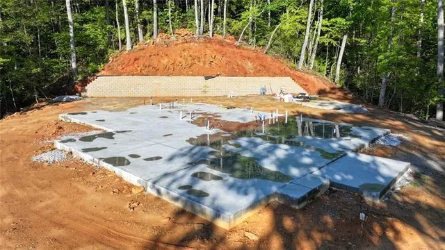 a swimming pool with large trees and wooden fence