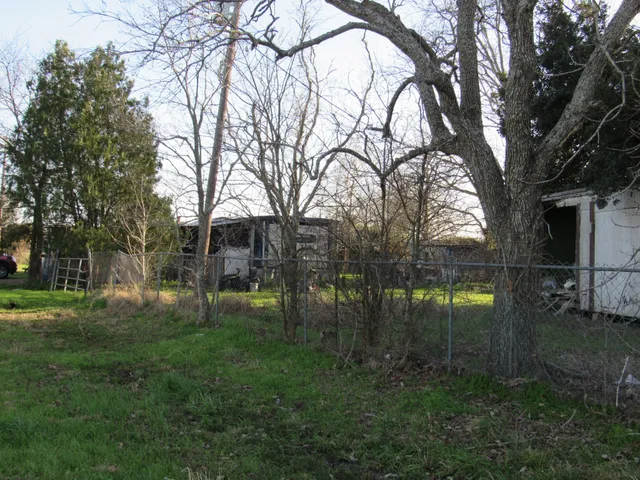 a backyard of a house with lots of green space and fountain