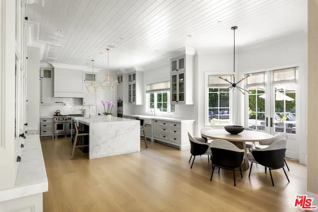 a dining room with furniture a chandelier and kitchen view
