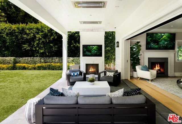 a view of a patio with couches fire pit and a yard