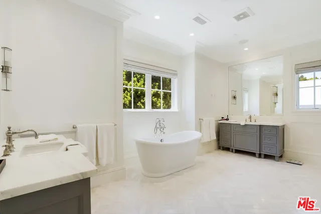 a bathroom with a bathtub sink and mirror