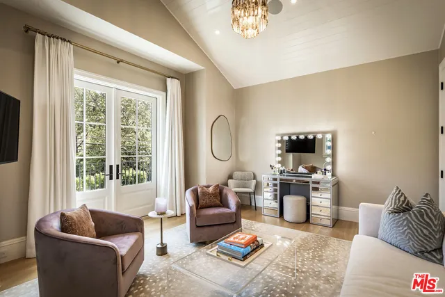 a living room with furniture a flat screen tv and a large window